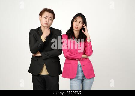 portrait of pensive asian Indonesian business man and woman with thinking gesture on isolated background Stock Photo