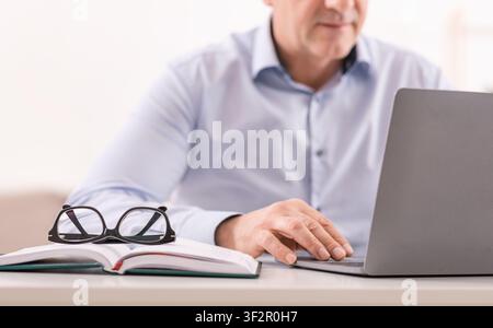 Unrecognizable mature man using laptop at office Stock Photo