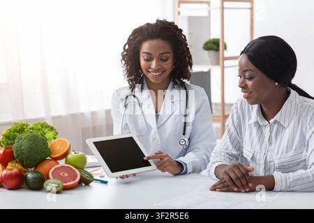 Dietologist using digital tablet in office, making patient's anamnesis Stock Photo