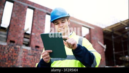 Civil engineer, online and man with tablet on construction site, scroll and planning for renovation. Outdoor, architect and person with technology Stock Photo