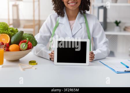 Cropped of african dietologist holding digital tablet with empty screen Stock Photo