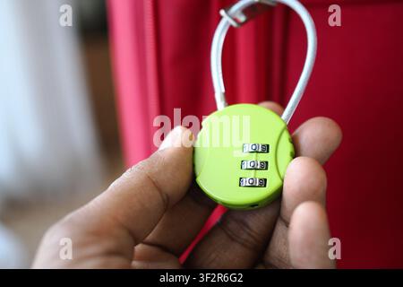 Lock shown on hand before being used on luggage Stock Photo