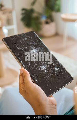 Person holding a broken tablet with a cracked screen Stock Photo