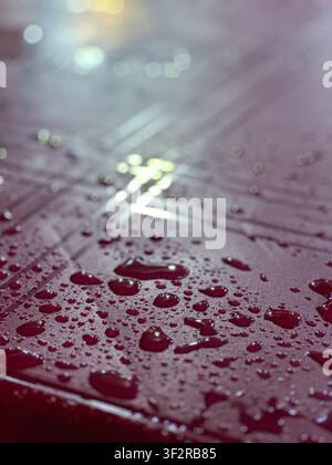 Close-up macro shot of water droplets on a wet textured surface with bright light reflection, Johor Bahru, Malaysia. Stock Photo