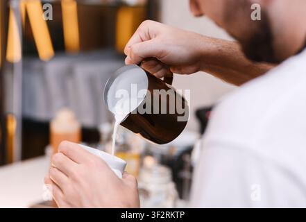 Unrecognizable Barista Making Cappuccino Adding Milk In Cup In Cafeteria Stock Photo
