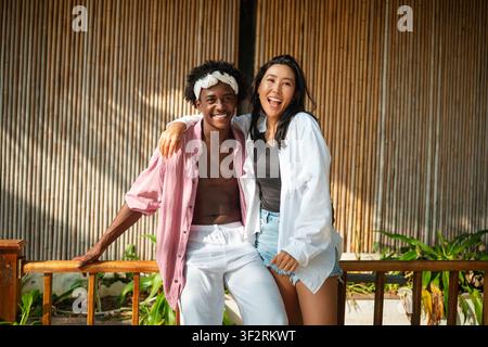 Happy interracial couple embracing and sharing a romantic moment during a tropical island getaway Stock Photo