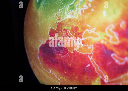 Shallow depth of field shot of a digital globe displaying extreme heatwave anomalies across Europe and Africa. A stark visual concept of global warmin Stock Photo
