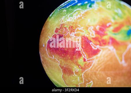 Close-up of a digital globe displaying a thermal weather map with extreme heatwave anomalies across Europe and Africa. A visual symbol of global warmi Stock Photo