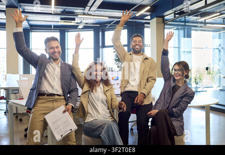 Diverse business team celebrating success in modern office, cheering together Stock Photo