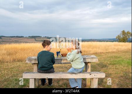 Brother and sister sitting together after outdoor craft activity Stock Photo