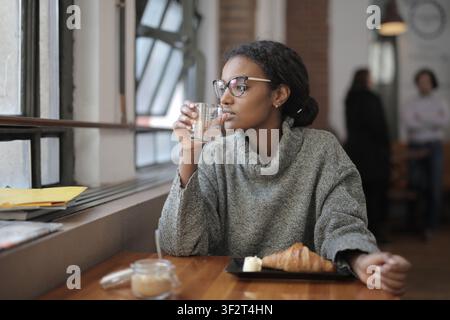 Thoughtful woman sitting alone in a coffee shop Stock Photo