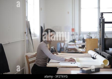 Young Black woman drafting plans in art studio Stock Photo