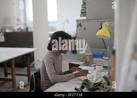 Young Black artist sketching in a creative studio Stock Photo