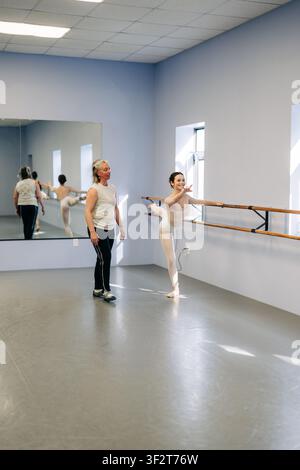 Ballet dancer practicing at barre with instructor Stock Photo