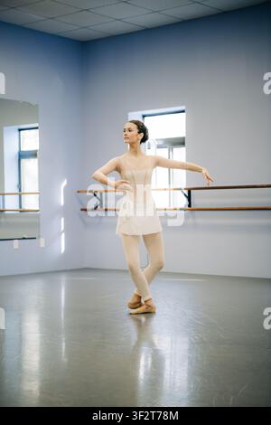 Ballerina practicing ballet steps in dance studio Stock Photo