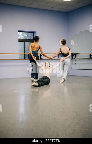 Dancers rehearsing modern choreography holding hands in studio Stock Photo