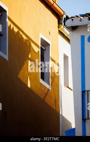 Minimalist Sun and Shadows on Yellow Facade in Villajoyosa Stock Photo