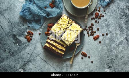 Layered chocolate cake slices topped with white shavings and nuts Stock Photo