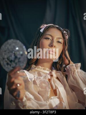 Woman in romantic blouse holding a small glitter balloon Stock Photo
