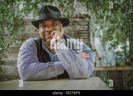 Confident Black man in fedora hat smiling outdoors Stock Photo