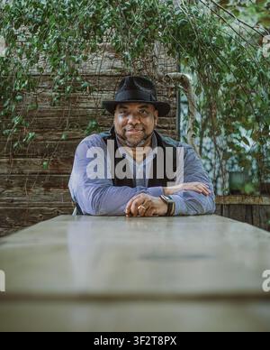 Stylish Black man in a fedora smiling outdoors Stock Photo