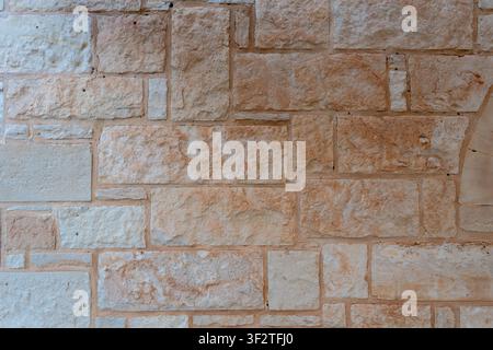 Texture of ancient masonry wall built from rectangular sand stones and beige limestone blocks of different sizes background. Stock Photo