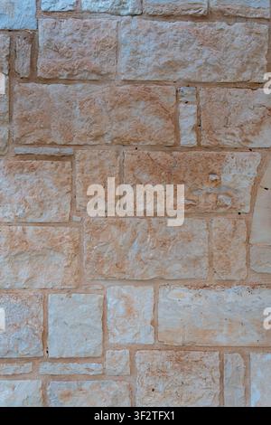 Texture of ancient masonry wall built from rectangular sand stones and beige limestone blocks of different sizes background. Stock Photo