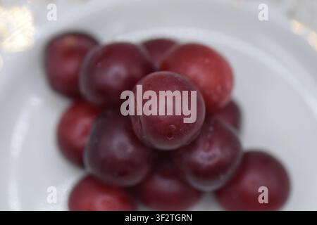Plate with overripe cherry plums on a white background. Isolated Stock Photo