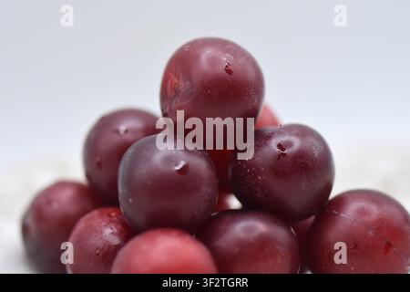Plate with overripe cherry plums on a white background. Isolated Stock Photo
