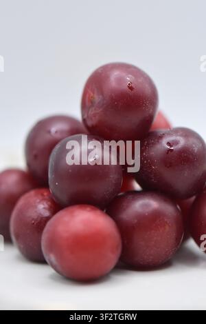 Plate with overripe cherry plums on a white background. Isolated Stock Photo