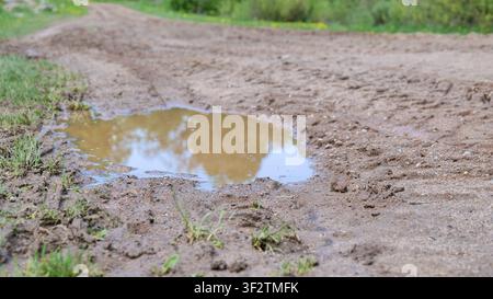 Muddy Road With Large Puddles After Rain Stock Photo