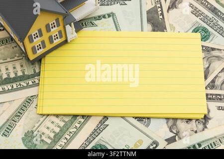 Blank lined index cards with car keys on twenty dollar bills for mortgage, insurance and maintenance Stock Photo