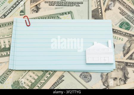 Blank lined index cards with car keys on twenty dollar bills for mortgage, insurance and maintenance Stock Photo