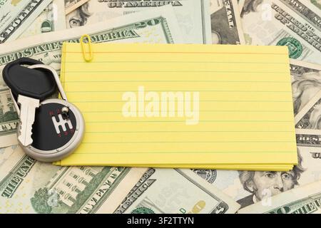 Blank lined index cards with car keys on twenty dollar bills for the cost of owning a car Stock Photo