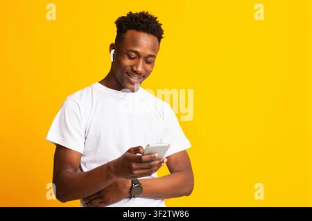 Smiling african young man in holding cellphone Stock Photo