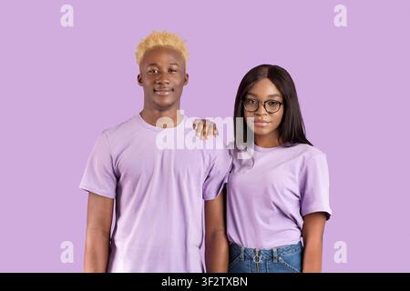 Portrait of handsome black man and his girlfriend in glasses posing and looking at camera over violet studio background Stock Photo