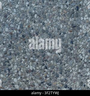 A top-down close-up of an exposed aggregate concrete surface filled with small multicolored pebbles and gravel. Stock Photo