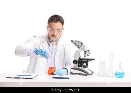 Lab researcher pouring chemical liquids and working with a microscope isolated on white background Stock Photo