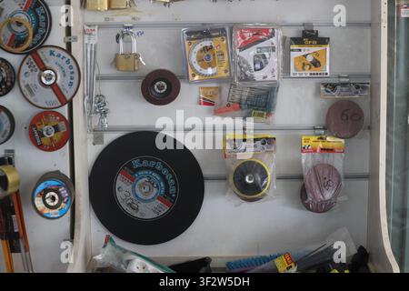 Assorted grinding discs, cutting wheels, and abrasive tools displayed on a hardware store retail rack Stock Photo