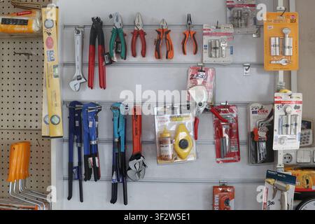 Various construction and hand tools displayed on a retail store wall organizer Stock Photo