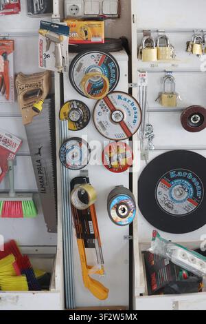 Various circular abrasive grinding discs and hand tools displayed on retail shelves in a hardware store Stock Photo