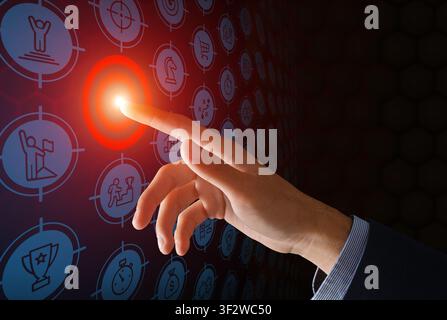 Achieving aims. Businessman pressijng red button on virtual screen with different icons, dark background. Collage Stock Photo