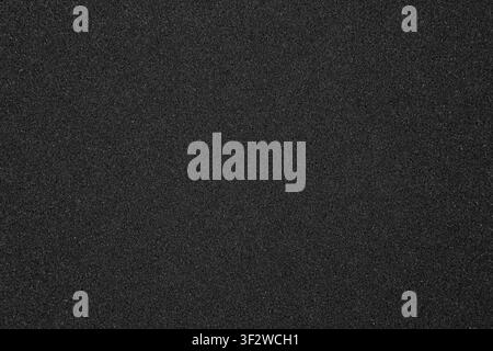 Texture of black synthetic sponge foam rubber sheet close up background. Stock Photo