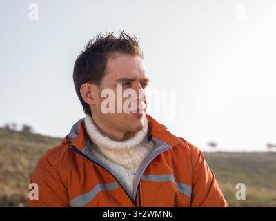 Portrait of young man wearing hiking clothes looking into distance Stock Photo