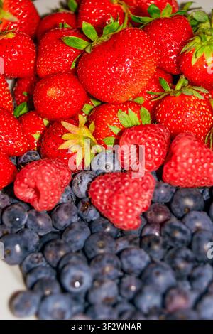 Close-up of fresh summer berries pattern with ripe strawberries, raspberries, and blueberries Stock Photo