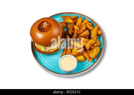 Cheeseburger with Potato Wedges and Creamy Dipping Sauce on Blue Plate Stock Photo