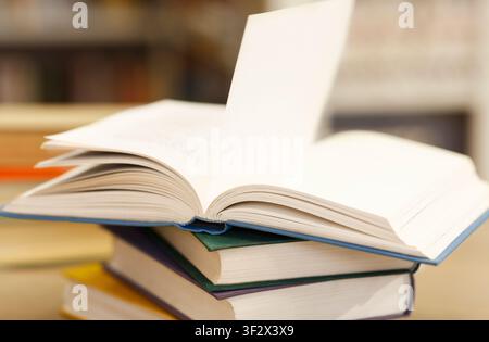 Open book lying on a stack of manuals Stock Photo