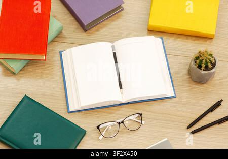 Close up of open book with glasses and cactus Stock Photo