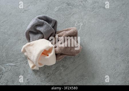 Three soft microfiber cleaning cloths arranged on gray textured background. Household cleaning and reusable fabric concept with copy space. Stock Photo