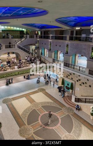 The JRA Tokyo Racecourse offers a striking indoor space, showcasing a multi-level design with intricate geometric mosaics under illuminated skylights. Stock Photo